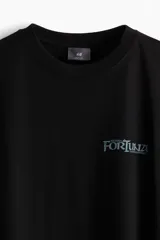 Remera negra de corte holgado con estampado pequeño en el pecho con la palabra 'Fortuna'.