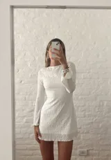 Minivestido blanco de manga larga acampanada, con cinturón marrón de cuero con apliques metálicos.