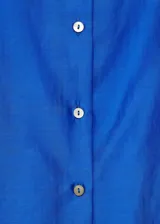 Camisa color verde claro de tejido satinado, manga larga con puños abotonados, diseño recto, cuello camisero y cierre delantero con botones.