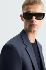 Blazer regular fit de hombre confeccionado en tejido con lana. Cuello con solapas de muesca, manga larga con puño abotonado, bolsillo de vivo en pecho, bolsillos de solapa en cadera, bolsillo interior, bajo con aberturas en espalda y cierre frontal de botonadura.