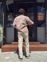 Camiseta color marrón de corte oversize con estampado de la marca Brixton y un hibisco en la espalda.