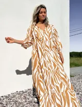Vestido largo tipo túnica con estampado de cebra en tonos beige y crudo, con cuello en V y mangas 3/4.
