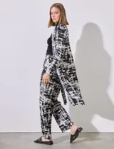 Cardigan plisado de satén, con aberturas laterales y diseño en tonos negros y blancos, de la marca Cyrus.
