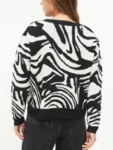 Sweater de punto con estampado abstracto de cebra en blanco y negro, de corte holgado y cuello redondo.