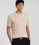 Remera de hombre color beige, corte slim fit, cuello redondo y manga corta. Tejido de punto acanalado texturizado.