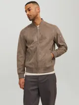 Campera bomber color marrón claro de cuero sintético, con cuello tipo baseball, cierre frontal con cremallera, bolsillos laterales con cremallera y bolsillo en la manga.