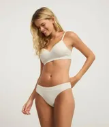 Bombacha de bikini color beige claro, confeccionada en poliamida con tecnología seamless y textura. Presenta un corte bikini clásico y un borde liso.
