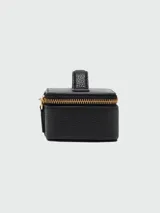 Estuche pequeño tipo caja de Marc Jacobs, color negro, con textura de cuero granulado y cierre de cremallera dorado. Posee un asa superior pequeña para transporte.