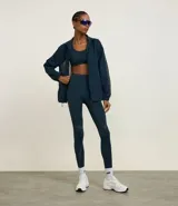 Campera deportiva tipo cortavientos en color azul petróleo, con cuello alto y cierre frontal completo. Presenta recortes de tul translúcido en los laterales, puños elásticos y bolsillos funcionales. Confeccionada en tejido de poliamida.