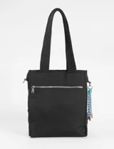 Bolso tipo shopper acolchado color beige claro, con costuras verticales onduladas en hilo azul. Posee dos asas de hombro y un pequeño accesorio colgante con cordones de colores en uno de los laterales. Presenta un logo cuadrado negro en el centro frontal.