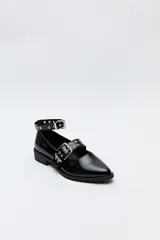 Zapato tipo zueco negro charol con punta fina, doble tira con hebillas metálicas y pulsera al tobillo con tachas.