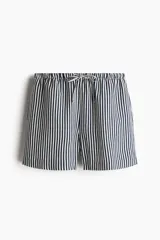 Short de corte holgado confeccionado en mezcla de lino y viscosa, con cintura elástica ajustable mediante cordón, bolsillos laterales y aberturas en los bajos.