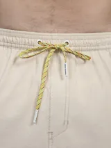 Short de baño verde con estampado de margaritas blancas y cordón ajustable naranja.