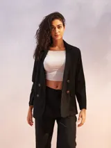 Blazer blanco de lino con doble botonadura y solapas de muesca. Tiene bolsillos delanteros con solapa y corte recto.