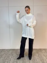 Polerón largo en color blanco con diseño clásico, detalles de trenzado y corte amplio.