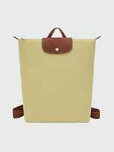 Mochila plegable Longchamp modelo Le Pliage Original, color beige claro, con solapa y asas de cuero marrón.