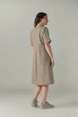 Vestido a la rodilla color beige, con escote en V, mangas cortas con detalle de tajo, bolsillos laterales y forro interior.