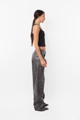 Pantalón gris de cuerina con estampado abstracto, corte recto y tiro medio.