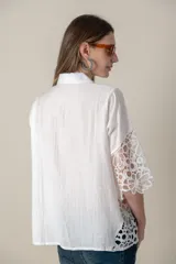 Camisa blanca lisa con aplique de guipiur en costados y mangas, de calce holgado.