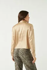 Camisa blanca de satén con corte relajado y largo a la cadera.