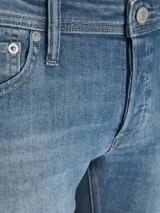 Jean de denim celeste con lavado stonewash, corte slim fit, tiro bajo, cinco bolsillos y cierre con botón.