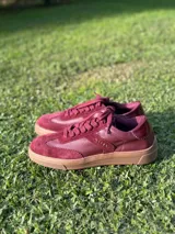 Zapatillas urbanas color bordó, con suela marrón.