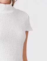 Remera blanca texturada de la marca Tahari, con cuello alto y manga corta.
