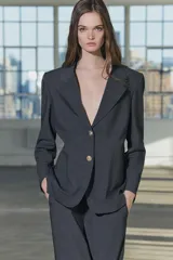 Blazer recta confeccionada en hilatura con viscosa, color gris oscuro. Tiene cuello solapa de muescas, manga larga con abertura y botones, bolsillos de plastrón en delantero, forro interior a tono y cierre frontal con botones.