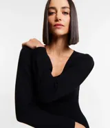 Vestido corto negro de punto con escote cuadrado y mangas largas.