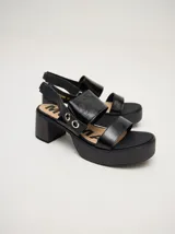 Sandalias negras de cuero con plataforma y taco ancho. Tienen correa trasera con elástico y doble argolla en la parte externa e interna.