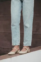 Zapatos estilo Mary Jane color beige, confeccionados en cuero, con taco cuadrado de 6 cm y tira con hebilla sobre el empeine.