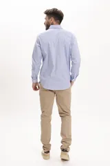 Camisa celeste a rayas verticales, de corte clásico, con cuello abotonado y mangas largas.