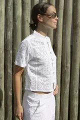 Blusa blanca con estampado de flores y cuello mao, con cierre frontal de botones.