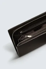 Bandolera rectangular color marrón oscuro con textura grabada. Tiene un compartimento principal con cierre de cremallera, seis ranuras para tarjetas, una ranura para billetes, monedero con cremallera, bolsillo trasero con botón a presión y asa de hombro ajustable y extraíble.