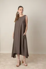 Vestido midi marrón de tejido tramado, corte suelto, sin mangas y con bolsillos laterales.