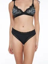 Conjunto de lencería con estampado de hojas en tonos verde y negro, con detalles de encaje negro. Incluye corpiño triangular sin aro y bombacha colaless.
