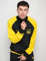 Campera deportiva de felpa negra con mangas amarillas en contraste y escudo del Club Atlético Peñarol estampado en el pecho.