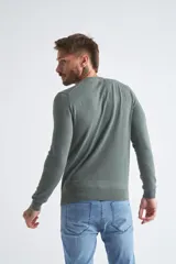Sweater de algodón en butoné color verde, con cuello redondo, puños y dobladillo acanalados, y logo bordado en el pecho.
