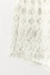 Mini shorts de tiro alto, color blanco, con cintura elástica y bordados florales.