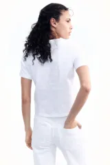 Remera blanca de algodón suave con cuello redondo ribeteado y bajo recto.