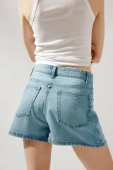 Minifalda de jean celeste con tiro medio, trabillas, cinco bolsillos y cierre frontal con cremallera y botón metálico.