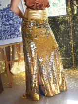 Pollera larga dorada de lentejuelas con cintura dorada y tajo lateral.