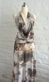 Vestido largo de microtul con estampado tie-dye en tonos rosa, verde y gris. Diseño con escote halter y espalda descubierta.