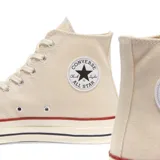 Championes Converse Chuck 70 Hi color beige con detalles en rojo y azul en la suela.