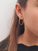 Aros tipo argolla dorados, de tamaño mediano.