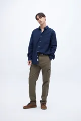 Camisa celeste de algodón, corte regular fit, con cuello solapa clásico, manga larga, bolsillo en el pecho y botones personalizados.