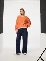 Sweater de punto jacquard color naranja con cuello y ruedo en rosa, de mangas largas y corte holgado.