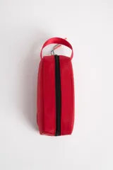 Necesser rojo rectangular de tela impermeable, con cierre superior negro, asa de mano y logo circular en relieve.