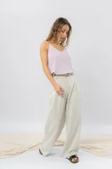 Pantalón de tiro medio color beige, con cintura con presillas para cinto, bolsillos laterales y pinzas delanteras.
