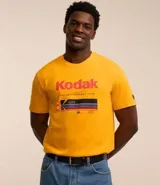 Remera amarilla de algodón con cuello redondo y mangas cortas. Estampado frontal con el logo de Kodak y un rollo de película.